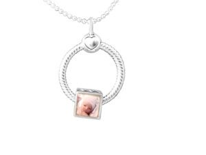 a silver necklace with a baby's photo on it