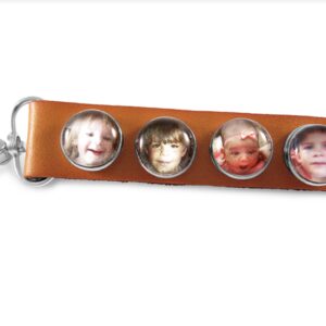 a leather key chain with three pictures of children