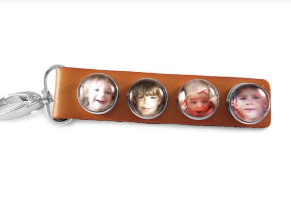 a leather key chain with three pictures of children