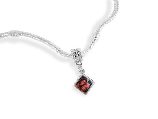 a silver necklace with a red square pendant