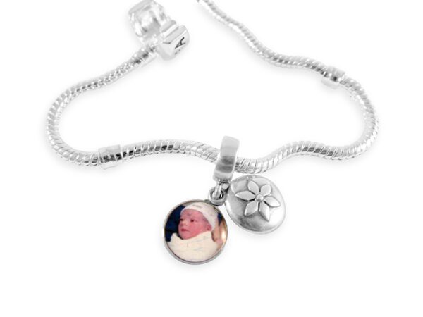 a silver necklace with a flower and a photo on it