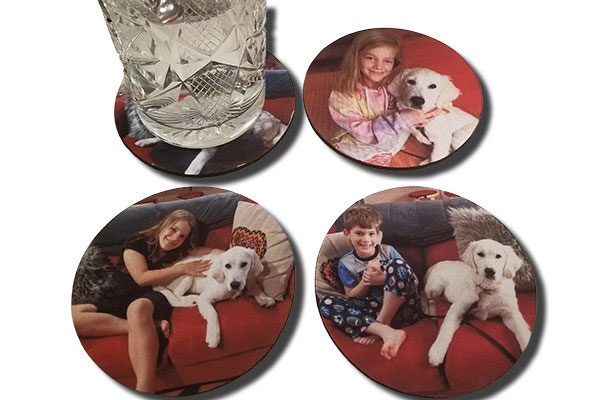 four coasters with pictures of people and dogs on them