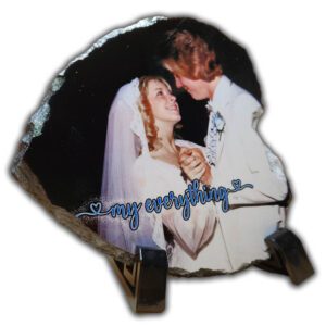 a bride and groom holding each other close together heart shaped photo slate